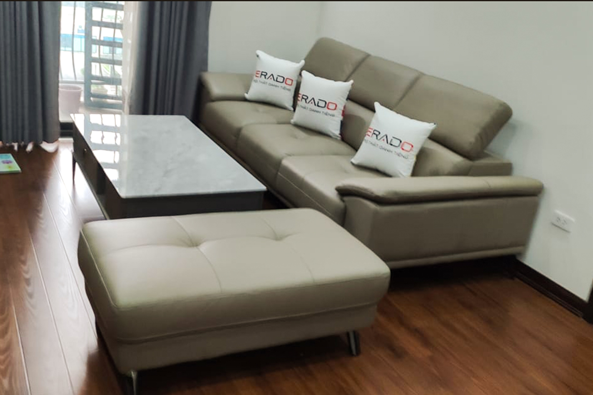 Bộ ghế sofa màu be sáng bọc da thật kèm đôn giúp phòng khách nhà chị Phương ở An Bình thêm hiện đại